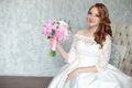 Portrait of beautiful red-haired girl sitting, smiling on big arm-chair. Royalty Free Stock Photo