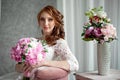 Portrait of beautiful red-haired girl sitting, smiling on big arm-chair. Royalty Free Stock Photo