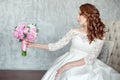 Portrait of beautiful red-haired girl sitting, smiling on big arm-chair. Royalty Free Stock Photo