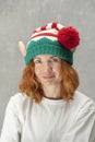 Portrait of a beautiful red-haired young girl in knitted elf hat. Vertical frame Royalty Free Stock Photo