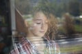 Portrait of Beautiful Redhead Girl Behind Glass with reflection