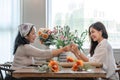 Portrait of a beautiful retired Asian woman focuses on arranging a vase with fresh flowers in a workshop. Lifestyle Royalty Free Stock Photo