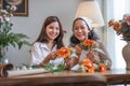 Portrait of a beautiful retired Asian woman focuses on arranging a vase with fresh flowers in a workshop. Lifestyle Royalty Free Stock Photo