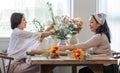 Portrait of a beautiful retired Asian woman focuses on arranging a vase with fresh flowers in a workshop. Lifestyle Royalty Free Stock Photo