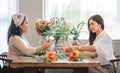 Portrait of a beautiful retired Asian woman focuses on arranging a vase with fresh flowers in a workshop. Lifestyle Royalty Free Stock Photo