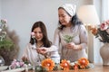 Portrait of a beautiful retired Asian woman focuses on arranging a vase with fresh flowers in a workshop. Lifestyle Royalty Free Stock Photo