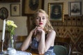 Portrait of beautiful retro lady sitting at table in the cafe. Royalty Free Stock Photo