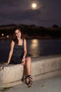 Beautiful romantic girl with the moon shining on the ocean