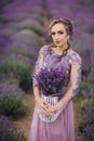 Portrait of beautiful romantic woman in field of lavender with basket of purple lavender flowers, summer time Royalty Free Stock Photo