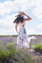 Portrait of beautiful romantic woman floral dress and stylish hat in field of lavender flowers Royalty Free Stock Photo