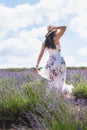 Portrait of beautiful romantic woman floral dress and stylish hat in field of lavender flowers Royalty Free Stock Photo