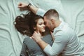 romantic young couple man woman in love hugging, kissing, lying on floor on white rug carpet