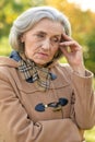 Beautiful sad elderly woman in autumn park Royalty Free Stock Photo