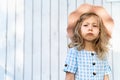 portrait of a beautiful sad little girl with blond curly hair in a hat Royalty Free Stock Photo