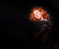 Portrait of a beautiful seductive sensual, young sexy redhead, a beautiful ginger woman with long curly red hair with black cloth Royalty Free Stock Photo