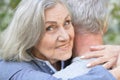 Portrait of beautiful senior couple hugging on a lilac background in the park Royalty Free Stock Photo