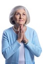 Portrait of beautiful senior woman in light blue blouse praying Royalty Free Stock Photo