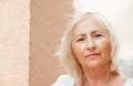 Portrait of beautiful senior woman with white hair standing by w Royalty Free Stock Photo