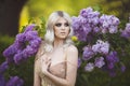 Portrait of a beautiful sensual young blond woman in spring. Blossoming spring garden. Young girl in a gold dress Royalty Free Stock Photo