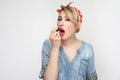 Portrait of beautiful sexual beauty blogger young woman in casual blue denim shirt with makeup and red headband standing, applying Royalty Free Stock Photo