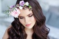 Portrait of a beautiful brunette girl with brown eyes in a delicate dress and a wreath of flowers on her head Royalty Free Stock Photo