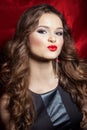 Portrait of a beautiful elegant girl brunette with long hair in evening dress with bright festive makeup and red lipstick Royalty Free Stock Photo