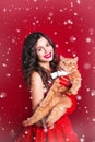 Portrait of beautiful girl wearing santa claus clothes with red british cat Royalty Free Stock Photo
