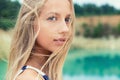 Portrait of beautiful girls with full lips and blond hair stands near the lake