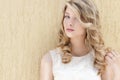 Portrait of a beautiful smiling happy girl with big full lips with blond hair in a white dress on a sunny bright day Royalty Free Stock Photo