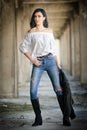 Portrait of beautiful young woman with modern outfit, leather jacket, jeans, white blouse and black boots Royalty Free Stock Photo