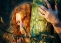 Portrait of beautiful sexy young woman, redhead hugging tree trunk in forest with friendly smile in the face, forest bathing,