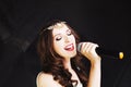 Portrait of beautiful singing woman on black background, close up Royalty Free Stock Photo