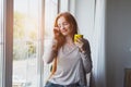 beautiful sleepy smiling young girl with yellow cup of fresh morning coffee to wake up