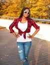 Portrait beautiful smiling african woman wearing a sunglasses, red checkered shirt posing in sunny autumn Royalty Free Stock Photo