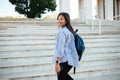Portrait of beautiful smiling asian woman with backpack going up Royalty Free Stock Photo