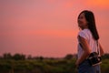 Portrait of beautiful smiling asian woman with holding medium format film camera with colorful sunset sky background