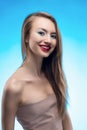 Portrait of the beautiful smiling blonde girl with red lips and