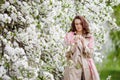 Portrait of a beautiful smiling brunette young women  in blossom apple tree garden in spring time. Enjoy Nature. Healthy girl Royalty Free Stock Photo