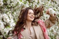 Portrait of a beautiful smiling brunette young women  in blossom apple tree garden in spring time. Enjoy Nature. Healthy girl Royalty Free Stock Photo