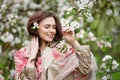 Portrait of a beautiful smiling brunette young women  in blossom apple tree garden in spring time. Enjoy Nature. Healthy girl Royalty Free Stock Photo