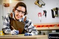 Portrait beautiful smiling carpenter woman in apron holds pencil and tape measure for measuring wood plank, female craft worker Royalty Free Stock Photo