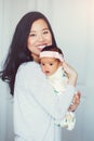 beautiful smiling Chinese Asian mother holding cute adorable newborn infant baby girl daughter. Royalty Free Stock Photo