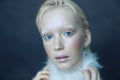 Portrait of a beautiful girl in the frost on his face on a blue ice background