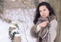 Portrait of a beautiful smiling girl near the tree in winter