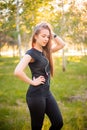 Portrait of a beautiful smiling girl in a sports uniform with flowing hair listening to music in headphones Royalty Free Stock Photo