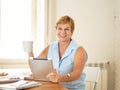 Portrait of a happy senior woman using electronic tablet at home Royalty Free Stock Photo