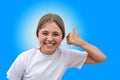 Portrait of beautiful smiling teenage girl giving thumbs up isolated on the blue background Royalty Free Stock Photo