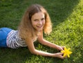 Portrait of a beautiful smiling teenage girl 12 years old lying on the grass on a sunny summer day Royalty Free Stock Photo