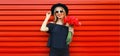 Portrait of beautiful smiling woman with bouquet of red rose flowers in black round hat on background Royalty Free Stock Photo