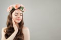 Portrait of beautiful smiling woman with clear skin, long shiny hair and flowers. Skincare and facial treatment concept Royalty Free Stock Photo